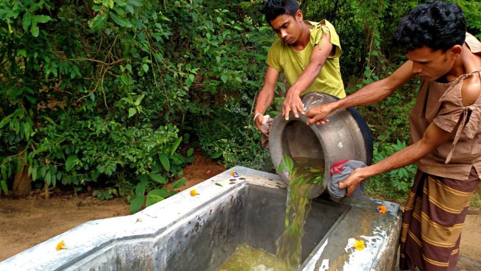 Pouring in a bath made from boiling Ayurvedic herbs