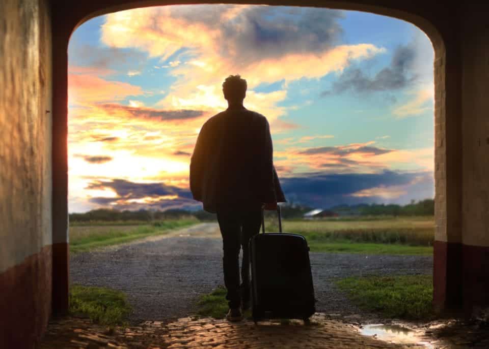 Man in doorway with suitcase