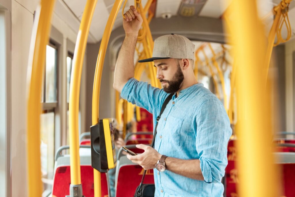 Young bearded man texting on smart phone in the bus.
