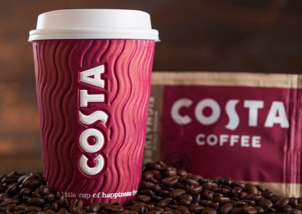 Costa Coffee Paper Cup with pack of Original Costa Coffee with beans on wood.