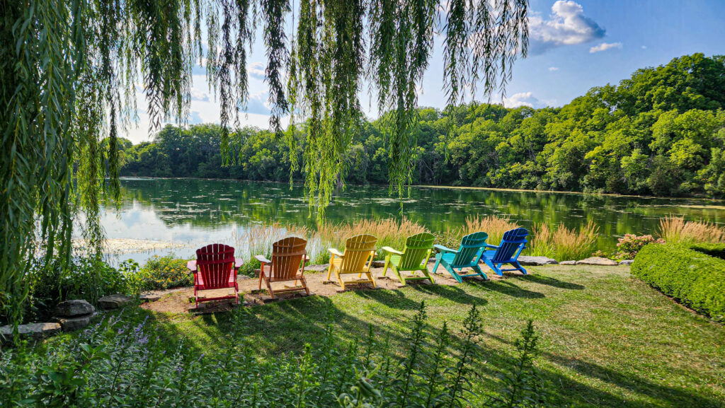 Fun things to do in Janesville - Adirondack chair overlooking a lake at Rotary Botanical Janesville Wi
