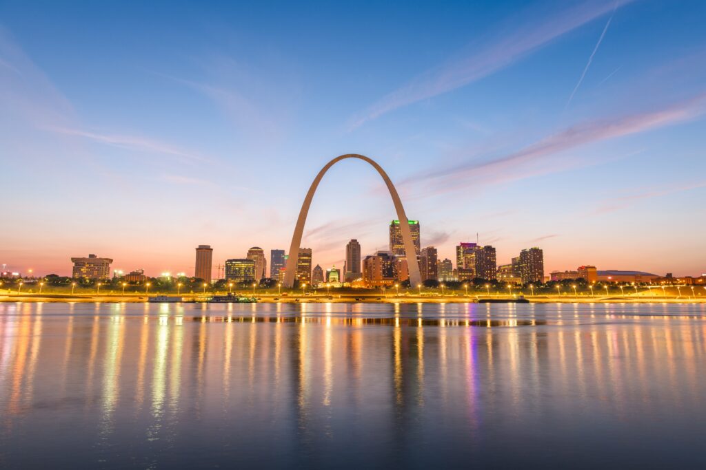 St. Louis, Missouri, USA, downtown cityscape with archway and courthouse at dusk.