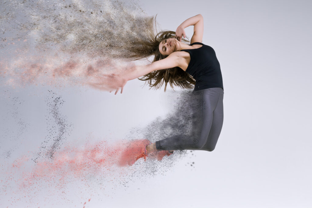 Woman in jump. Frozen motion. Photo manipulation of disintegration