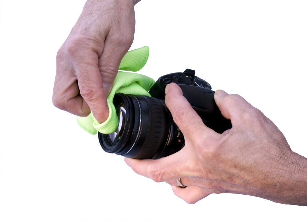 photographer cleaning a camera lens with a micro cloth isolated with a clipping path at original size
