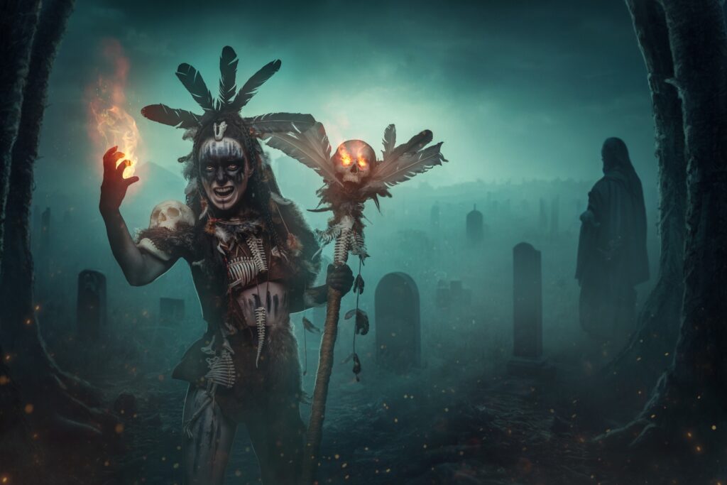Shot of screaming dark sorcerer dressed in aboriginal attire in foggy cemetery.
