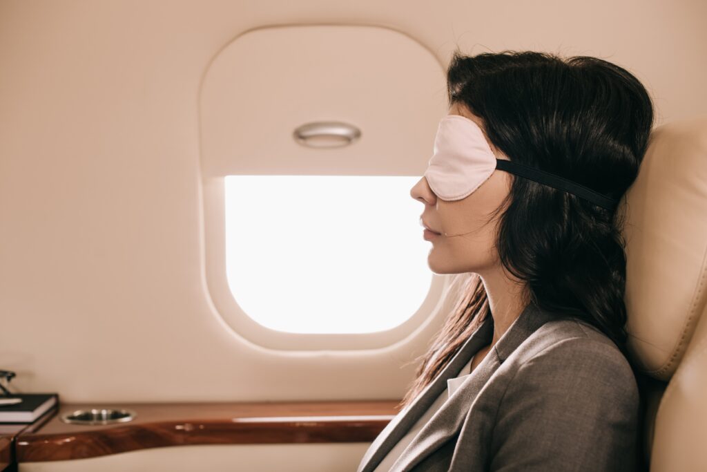 Sleeping woman wearing an eye mask on a plane