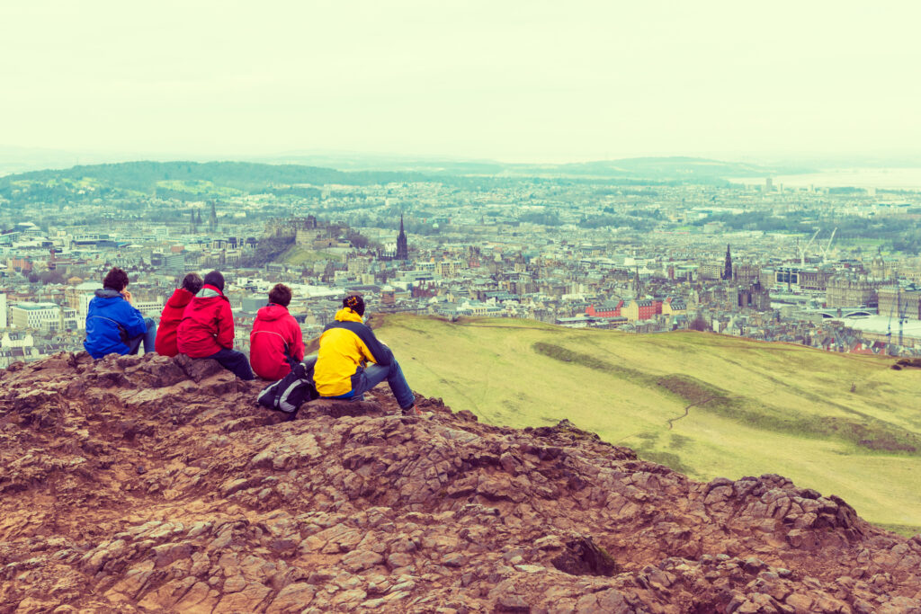 Family enjoying view of Edinburgh from top of Arthurs seat, ancient volcano, Scotland, UK