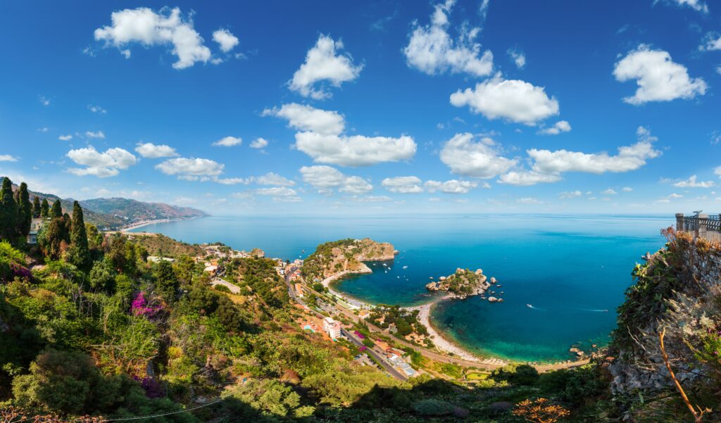 Beautiful Taormina panoramic view from up (Stairs to Taormina), Sicily, Italy. Sicilian seascape with coast, beaches and island Isola Bella. People unrecognizable.